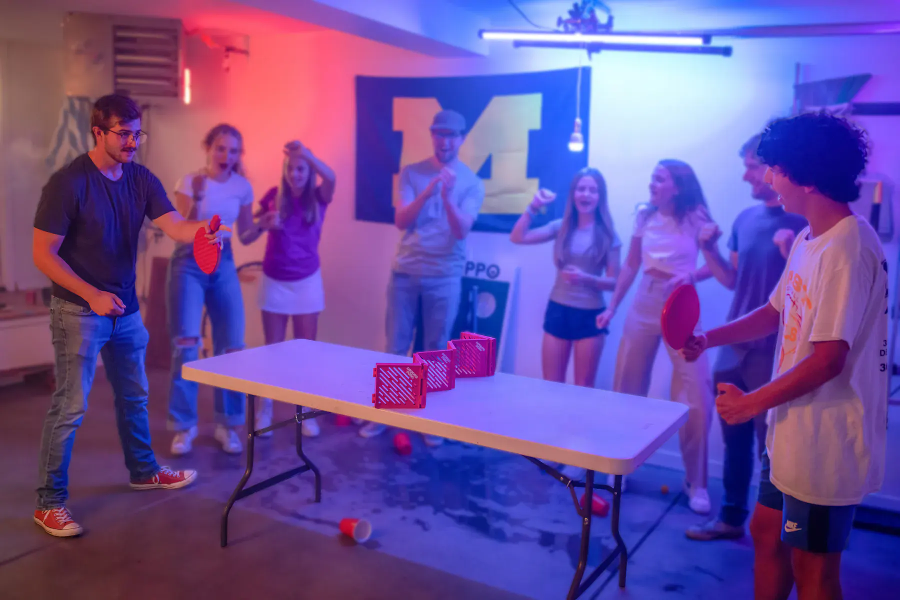 Pepper Pong players competing while a crowd reacts behind them