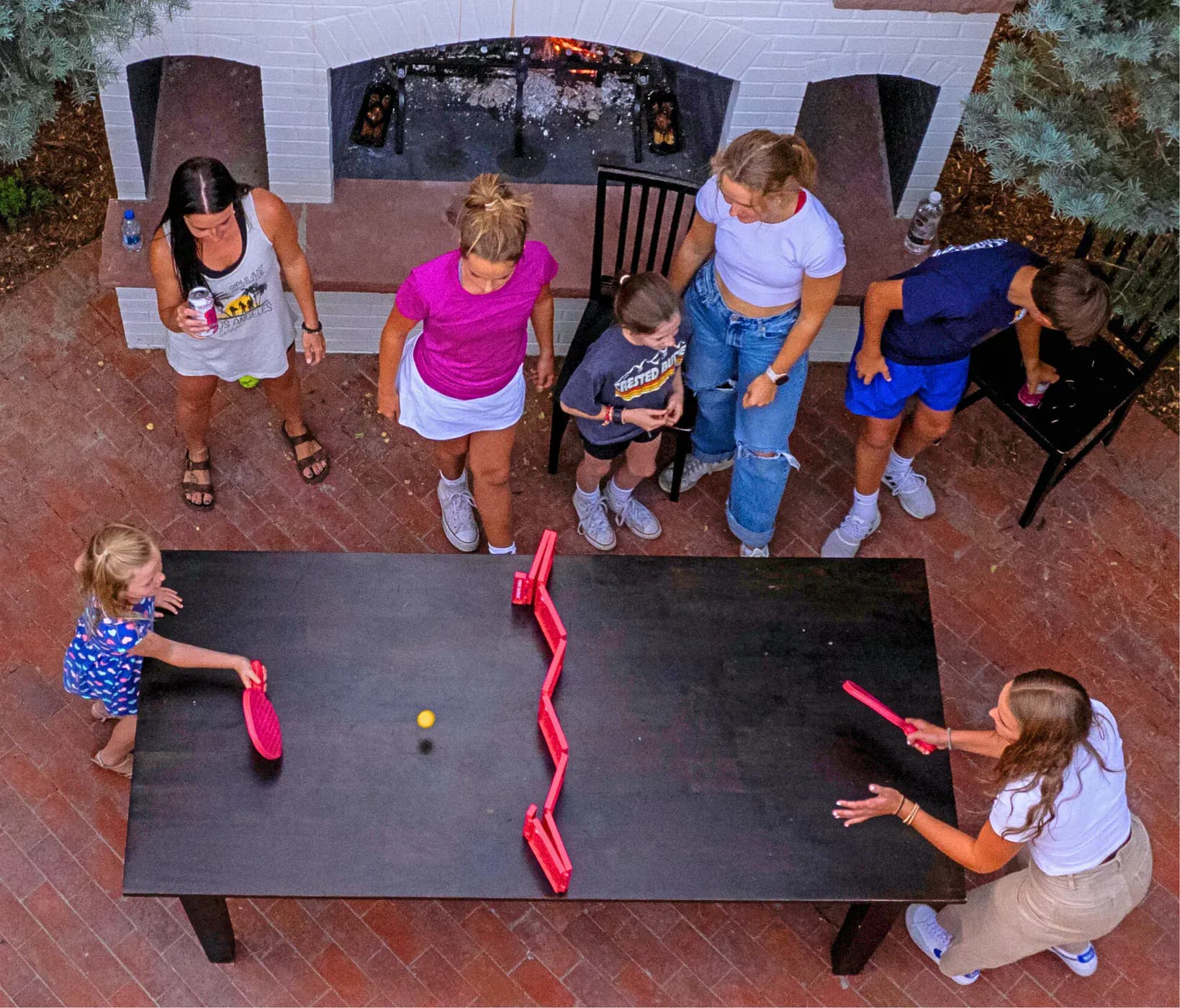 A group rotating through Pepper Pong matches around one table